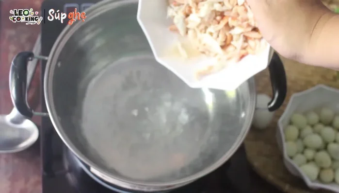 Cho thịt ghẹ, nấm rơm vào nồi nước sôi.
