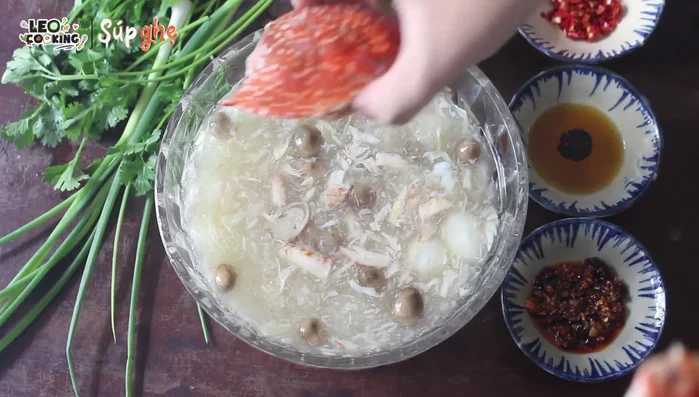 Múc súp ra tô, trang trí thêm hành ngò, tiêu, ớt xay và dầu mè.