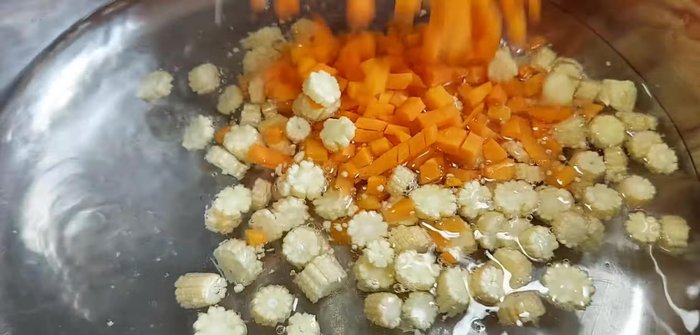 Khi nước dừa sôi, cho bắp non, cà rốt và bắp ngọt vào nấu cho chín mềm.
