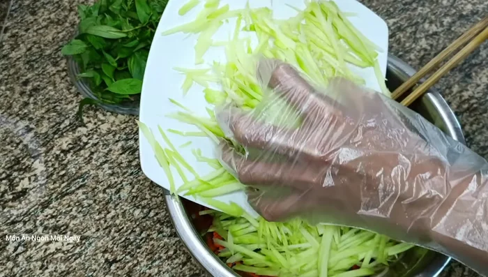 Trộn rau củ đã vắt ráo nước với phần sốt còn lại. Thêm xoài thái sợi, rau thơm, ớt (390.139).