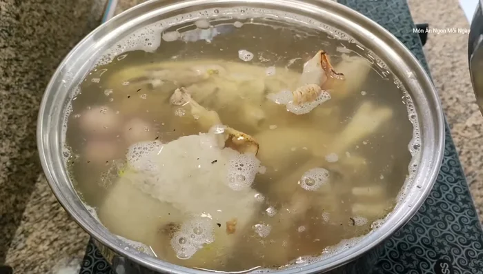 Sau khi nước sôi trở lại, cho hành tím, củ cải trắng (nếu dùng), củ sắn và cà rốt vào nấu.