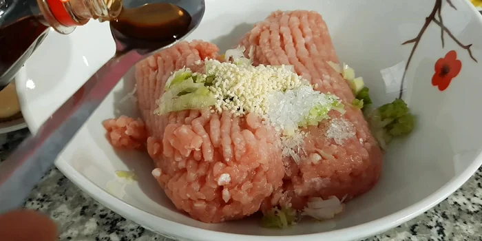 Ướp thịt xay với 1 muỗng cà phê hạt nêm, 1/2 muỗng cà phê bột ngọt, 1 muỗng cà phê nước mắm, 1 ít tiêu và hành tím băm nhỏ. Ướp trong 10 phút.