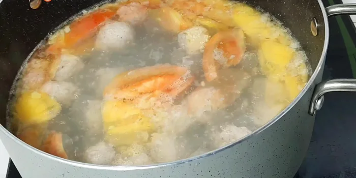 Đun sôi, hớt bọt. Cho đậu bắp, phần cà chua và khóm còn lại vào.