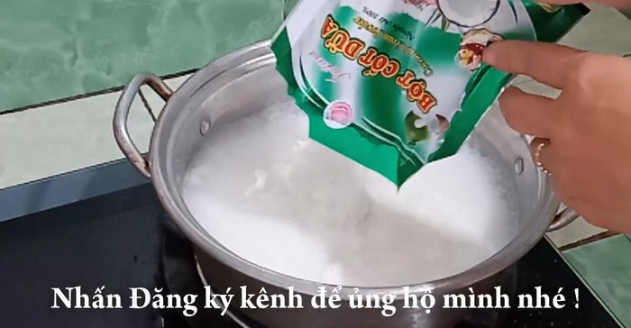 Cho bột cốt dừa vào hỗn hợp nước đường sữa đang sôi, khuấy đều cho tan.