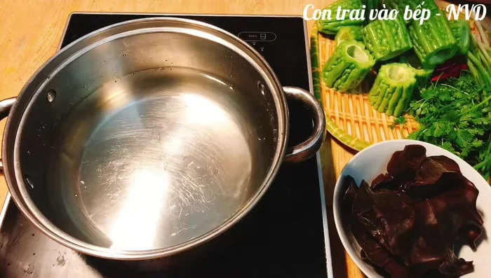 Chần mướp đắng qua nước sôi có pha chút muối, sau đó ngâm vào âu nước đá để giảm bớt vị đắng và giữ màu đẹp.