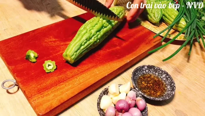 Rửa sạch mướp đắng với nước muối, cắt khúc vừa ăn, thái khoanh tròn. Dùng thìa khoét bỏ phần ruột và hạt bên trong.
