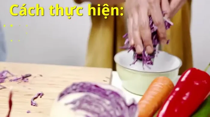 Bắp cải tím rửa sạch, cắt sợi mỏng. Thêm 2 thìa muối, trộn đều. Sau đó, vắt kiệt nước cho sạch. Làm lại lần nữa để bắp cải giòn lâu hơn.