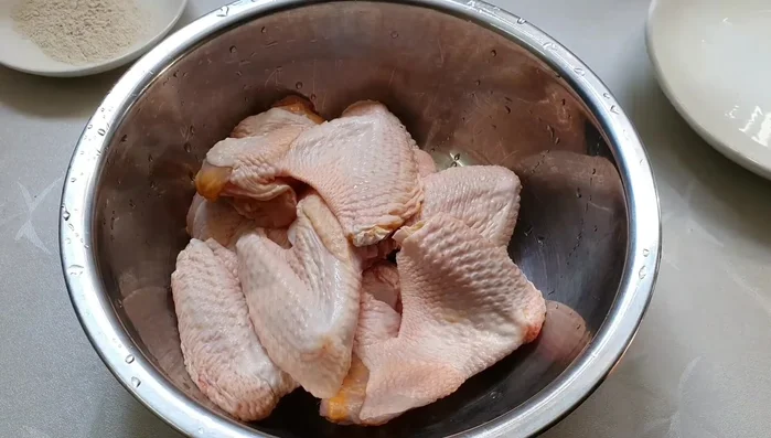 Rửa sạch cánh gà với muối hột và rượu trắng, chà xát kỹ từng miếng gà để loại bỏ mùi hôi. Rửa lại với nước sạch 2-3 lần.
