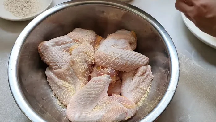 Ướp cánh gà với 2 thìa cà phê bột ngọt, 1 thìa cà phê hạt nêm, đường, tiêu xay, hành tỏi băm nhỏ. Trộn đều và ướp trong 1 giờ để gia vị ngấm.