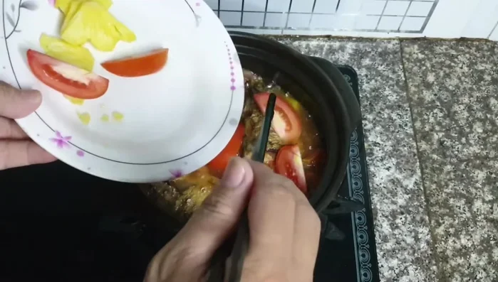 Cho phần cà chua và thơm còn lại vào, kho thêm 5-7 phút.