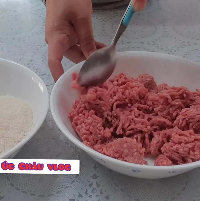 Cho thịt bò băm vào nồi, thêm 1 muỗng cà phê muối, 2 muỗng cà phê đường, 1 muỗng cà phê tiêu và hành tím băm nhỏ. Trộn đều.