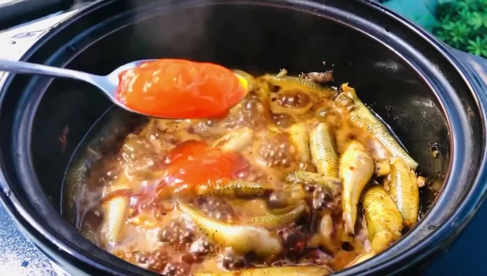 Thêm tương ớt vào, đảo đều. Kiểm tra cá, lật mặt để gia vị thấm đều.