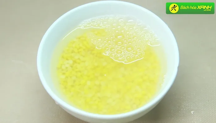 Rửa sạch đậu xanh và ngâm trong khoảng 3 tiếng. Thêm 1 muỗng canh đường, trộn đều và để ngâm khoảng 1 tiếng.