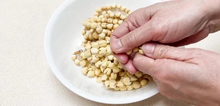 Ngâm hạt sen khô với nước ở nhiệt độ phòng trong 4 giờ. Sau đó, rửa sạch hạt sen, loại bỏ những hạt hư, nhụy và phần đầu đen.