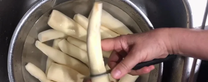 Cắt khoai mì thành từng đoạn vừa ăn.