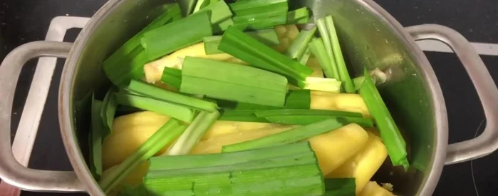 Cho khoai mì vào lại nồi, thêm lá dứa đã cắt nhỏ, vặn nhỏ lửa, nấu khoảng 10-15 phút cho đến khi khoai mì khô ráo.