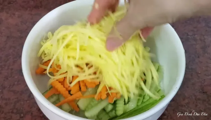 Trộn dưa leo, cà rốt, xoài xanh với đường, để thấm (5-10 phút).