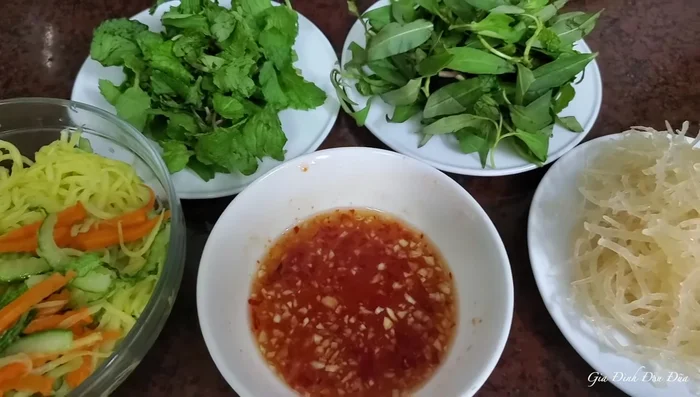 Trộn đều các nguyên liệu: rong sụn, đậu phụ, dưa leo, cà rốt, xoài xanh, rau răm, rau húng lủi.