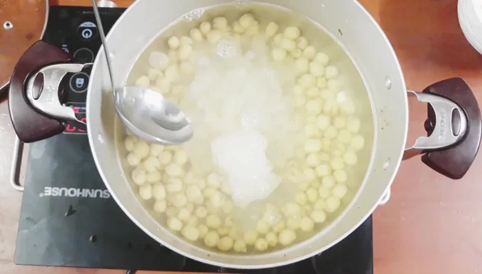 Cho đường phèn vào, khuấy đều đến khi tan hết. Thêm một ít muối để cân bằng vị ngọt.