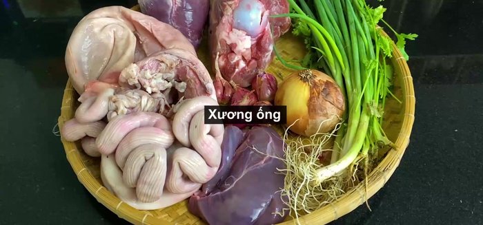 Sơ chế xương ống, tim, bao tử, trường, gan heo bằng cách trụng qua nước nóng để loại bỏ váng, rồi rửa sạch lại. Cho xương ống vào nồi, thêm khoảng 3 lít nước, 1 củ hành tây, củ cải trắng, 2 muỗng cà phê muối, 1 muỗng canh đường phèn.