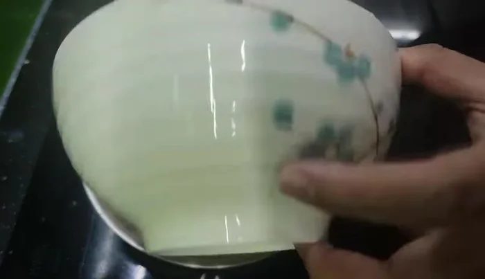 Cho phần thịt ghẹ còn lại vào cháo đang nấu trong nồi cơm điện, quấy đều khoảng 5 phút. (120.039)