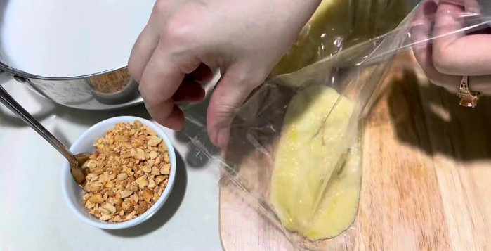 Múc kem dừa cho lên trên lớp chuối, rồi rắc đậu phộng lên trên.