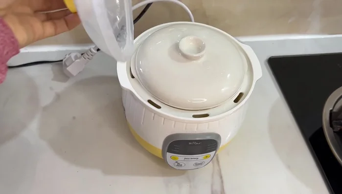 Cháo chín, múc ra tô. Cho cá đã xào vào, khuấy đều.