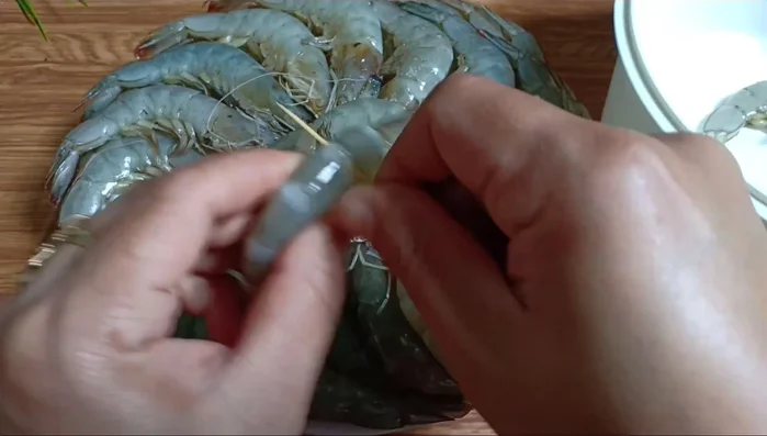 Làm sạch tôm: Cắt bỏ đầu, đuôi và phần phân trên lưng tôm bằng cây tăm. Rửa sạch tôm.