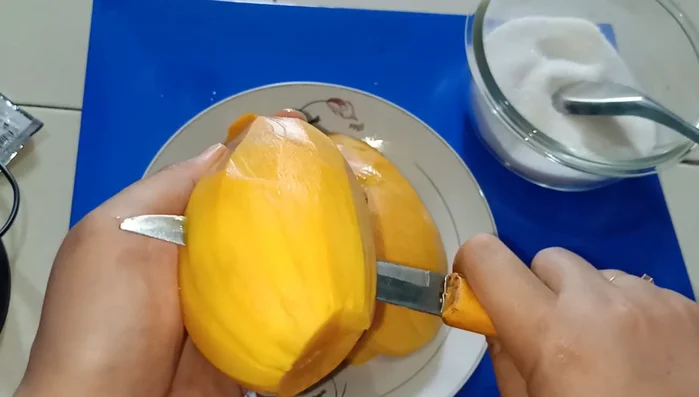 Gọt vỏ và cắt xoài thành miếng nhỏ vừa ăn. (Lựa xoài chín ngọt sẽ ngon hơn)
