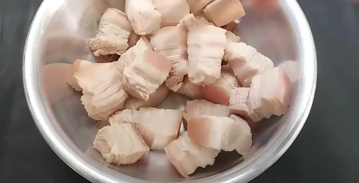 Cho thịt vào tô, thêm đường, nửa muỗng hạt nêm, hành, tỏi, ớt băm nhỏ, 1 muỗng canh nước màu, 2 muỗng canh nước mắm. Trộn đều.