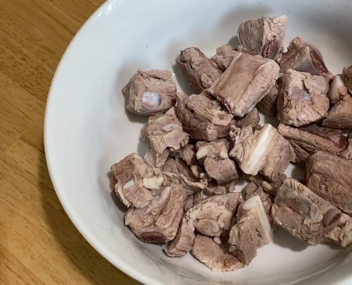 Cho sườn heo vào nồi, thêm nước, hành tây, cà chua và gia vị (tỏi, tiêu, muối, đường, bột nêm gà, dầu ăn) vào. Nấu khoảng 20 phút.