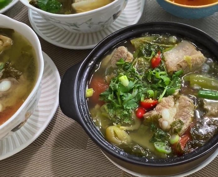 Tắt bếp và thưởng thức canh sườn heo dưa cải chua cùng với bún.