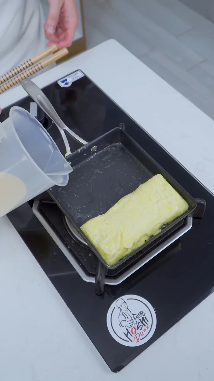 Làm tương tự với lớp trứng thứ ba. Cuốn chặt tamagoyaki lại.