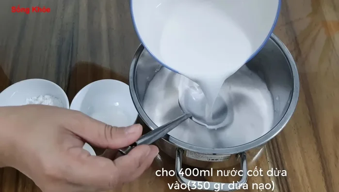 Làm nước cốt dừa: Cho 350g cốt dừa tươi, 35g đường (khoảng 2 muỗng canh), 1/2 muỗng cà phê muối, 6g bột năng (khoảng 4 muỗng cà phê) vào nồi. Khuấy đều. (152.39)