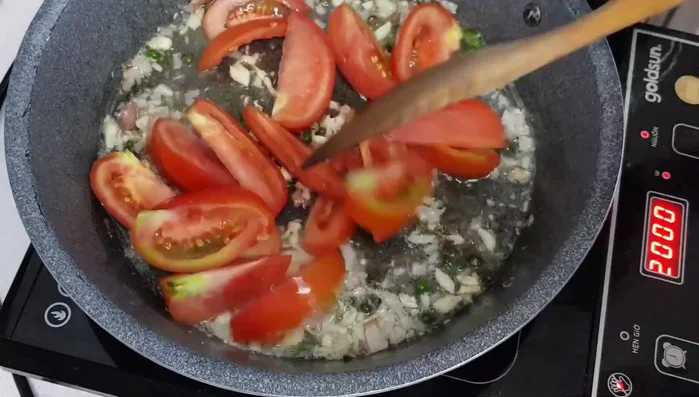 Cho cà chua vào xào sơ.