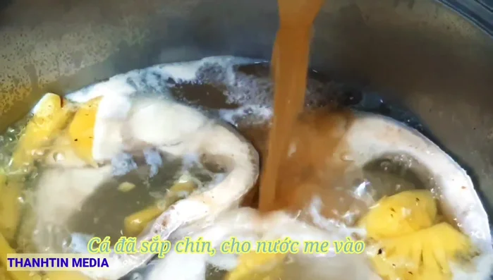 Khi cá chín, cho nước me vào nồi.