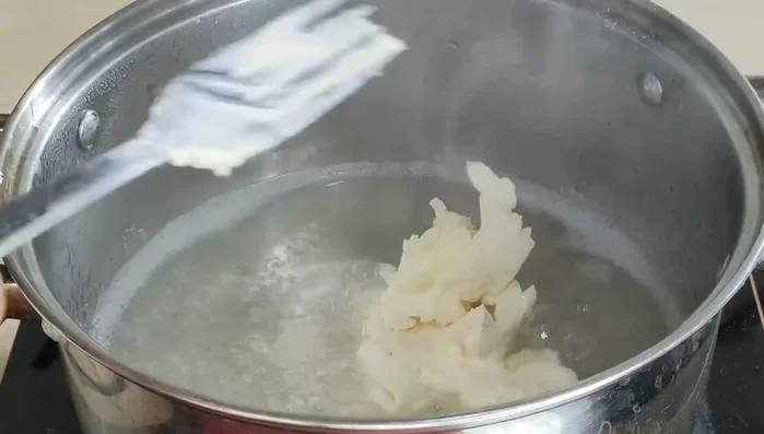 Cho phô mai đã tán nhuyễn vào hỗn hợp rau câu, khuấy đều cho tan.