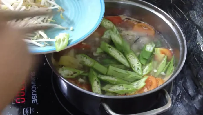 Cho đậu bắp và giá vào nồi, đun đến khi canh sôi.