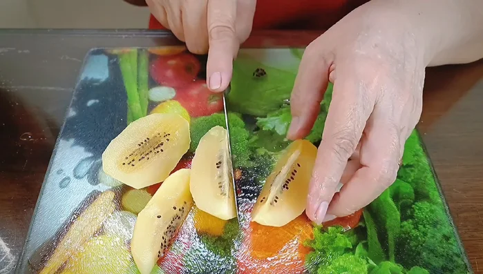 Gọt vỏ và cắt trái cây thành từng miếng nhỏ: kiwi, dâu tây (cắt làm 4), nho Mỹ (cắt đôi), mít Thái, thanh long đỏ (cắt làm 4).