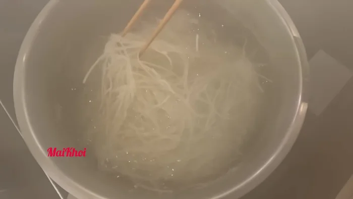 Luộc bún khô với một ít giấm cho đến khi mềm, sau đó vớt ra xả nước lạnh cho ráo.