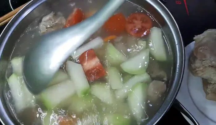 Tắt bếp, cho hành lá, rau thơm vào, múc canh ra bát và thưởng thức.