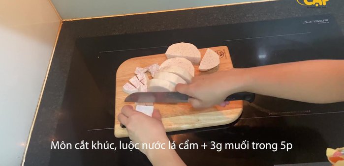 Cắt khoai môn thành khúc vừa ăn. Luộc khoai môn với nước lá cẩm và 3g muối khoảng 5 phút cho khoai môn có màu tím đẹp và đỡ ngứa.