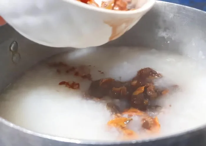 Cho sò vào cháo, quậy đều và tắt bếp.