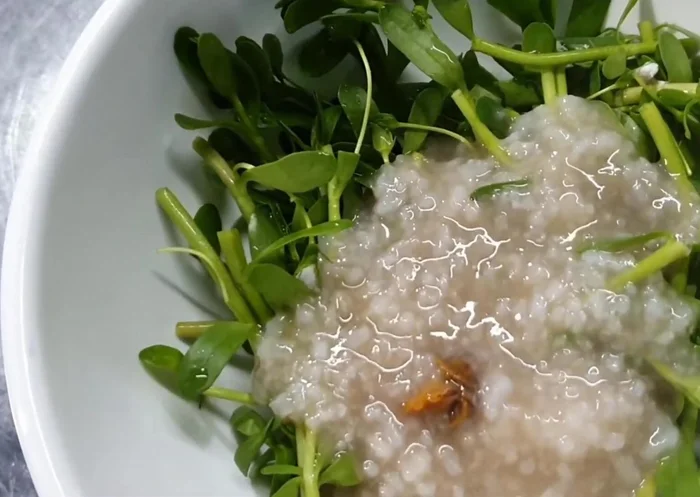 Cho rau đắng vào tô, múc cháo vào.