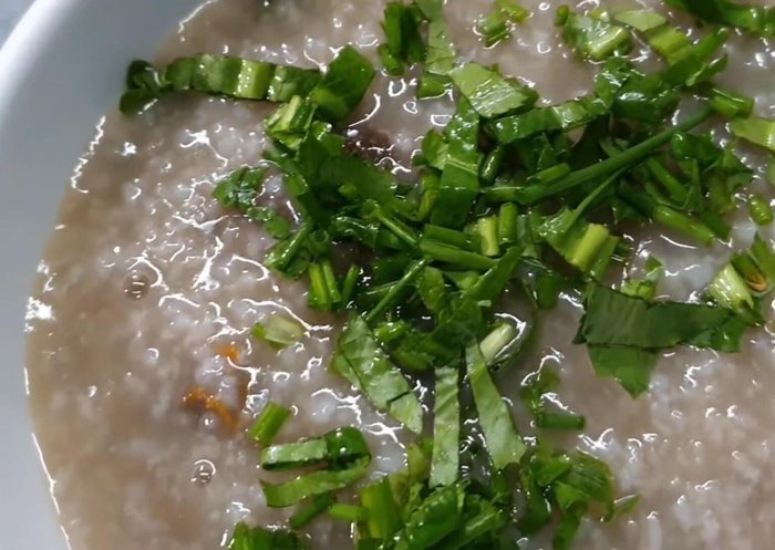 Thêm mỡ tỏi, hành, ngò gai, tiêu (nếu thích) và chanh vào tô cháo.