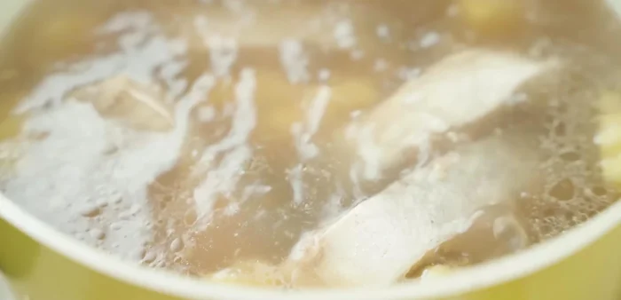 Cho cá đã chiên vào nồi, đun sôi 3 phút. Thêm cà chua, bạc hà, giá đỗ vào.