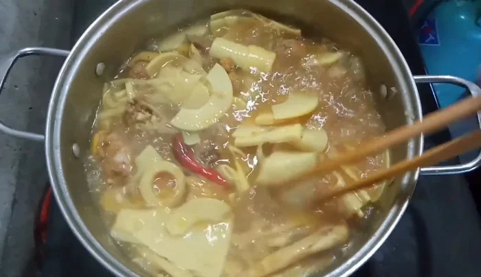 Đậy vung, nấu sôi khoảng 15 phút cho thịt gà chín và măng ngấm gia vị. (407.36)