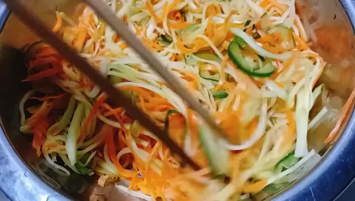 Trộn gỏi: Cho sứa, xoài, cà rốt, dưa leo, hành tây, rau thơm vào tô lớn. Thêm nước sốt đã pha vào trộn đều.