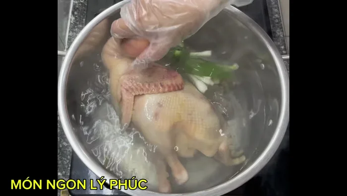 Cho gà vào nồi nước đang sôi, trụng qua rồi vớt ra xả lại nước. (251.36)