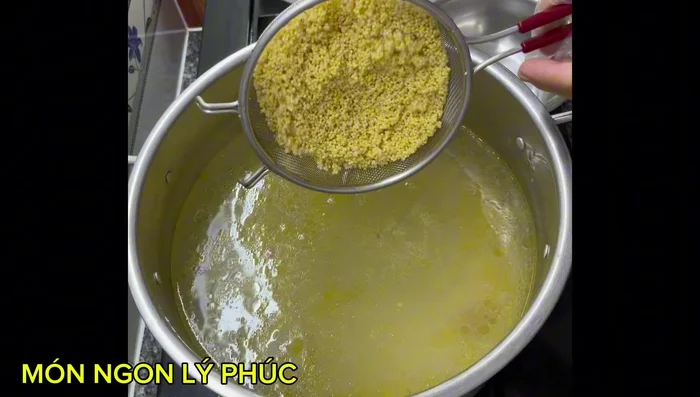 Cho gạo, hạt kê, hạt sen vào nồi nước dùng. Đun sôi, khuấy đều. (428.24)